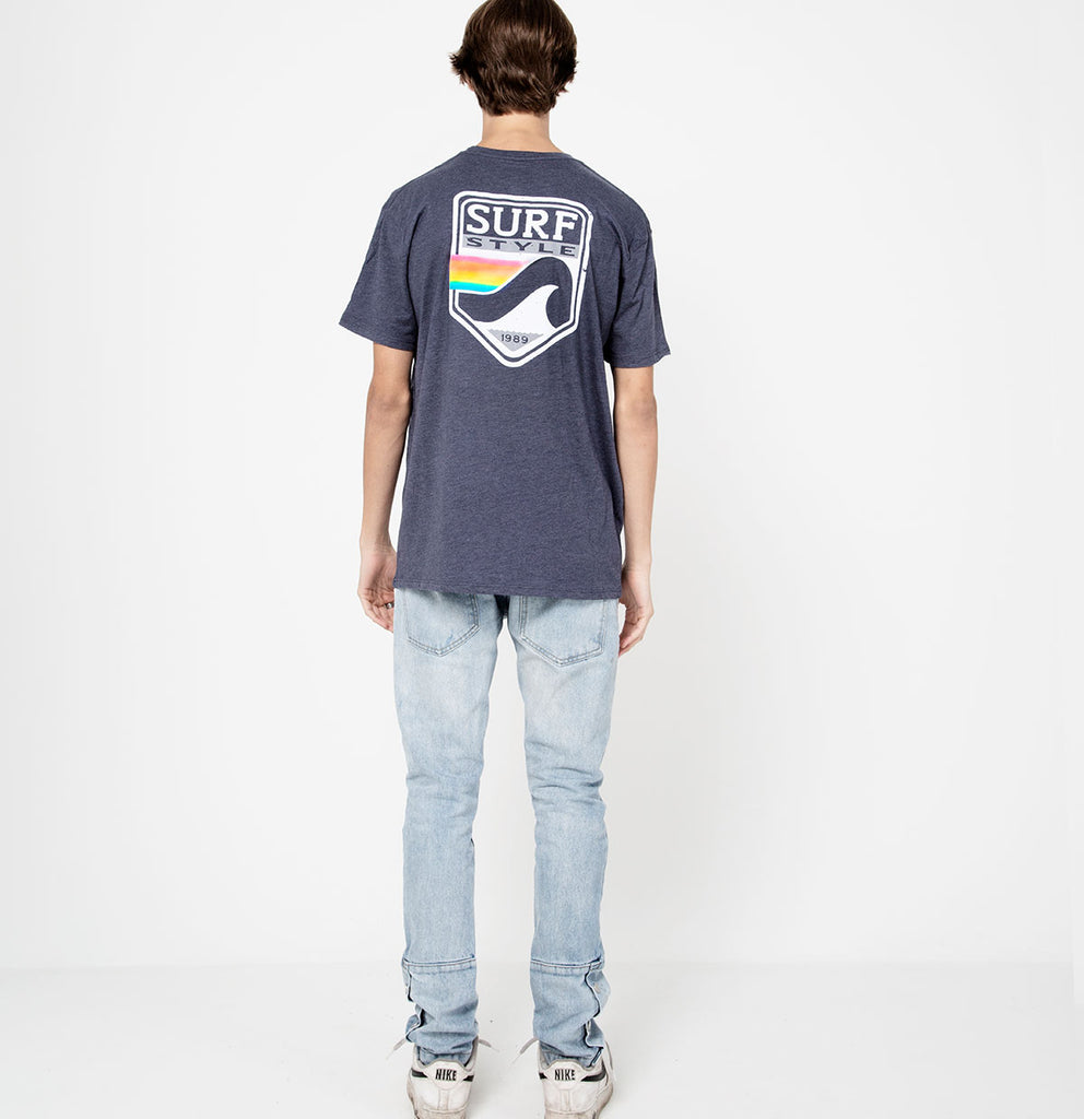 male showing the back design on the Surf Style Pastel Shield shirt on heathered blue shirt